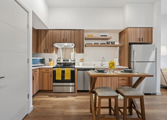 a kitchen with wooden cabinets and a table with two stools