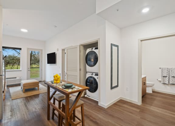 a living room with a table and a washing machine
