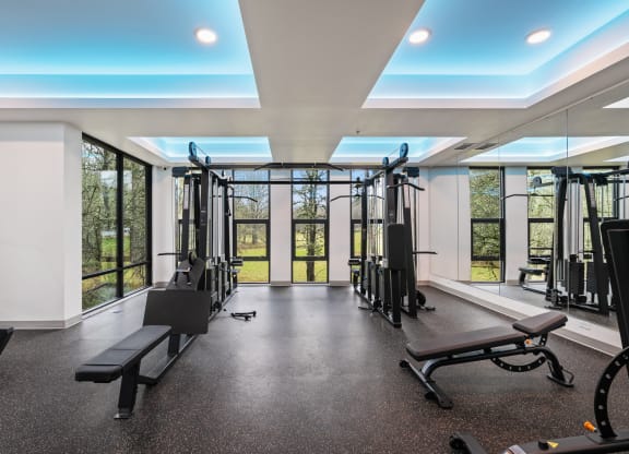 a gym with exercise equipment and windows in a building with glass doors