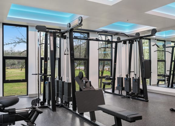 a gym with exercise equipment and windows in a building
