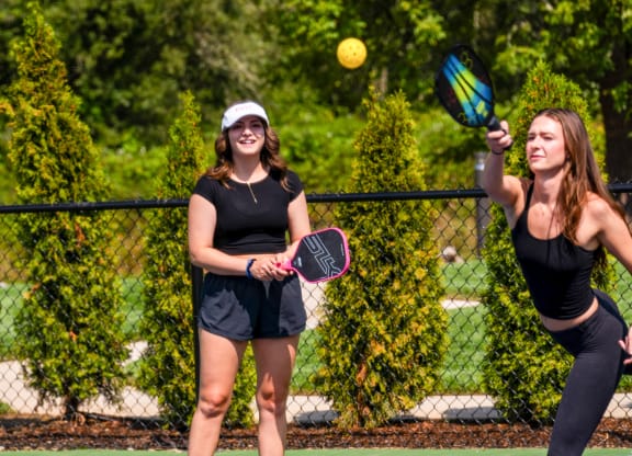 two women playing tennis on a tennis court
