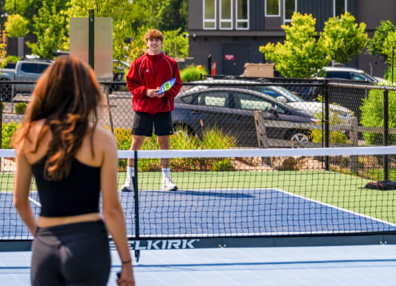 a man and woman playing tennis on a tennis court