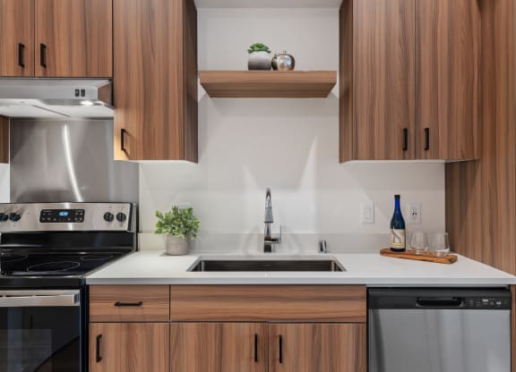 a kitchen with wooden cabinets and white counters and a sink