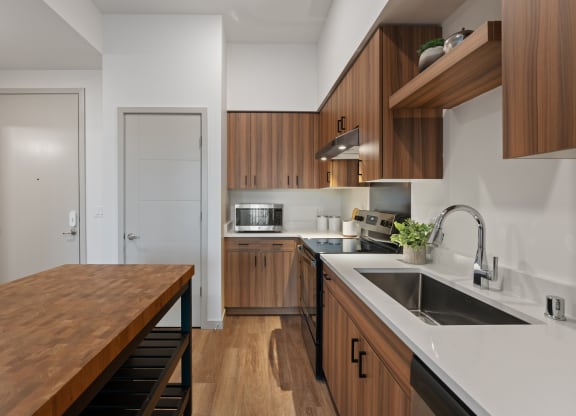 a kitchen with wooden cabinets and white countertops and a sink
