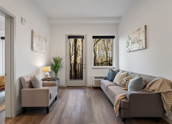 a living room with a couch and two chairs and a door