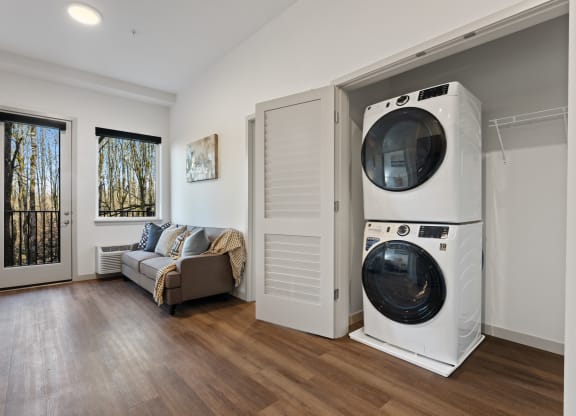 a washer and dryer in a room with a door to a living room