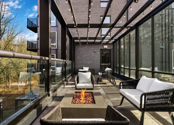 a patio with chairs and a fire pit