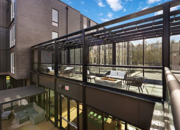 a balcony with a seating area and a patio with tables and chairs