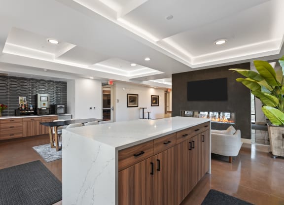 a large kitchen with a marble counter top and a bar and a living room
