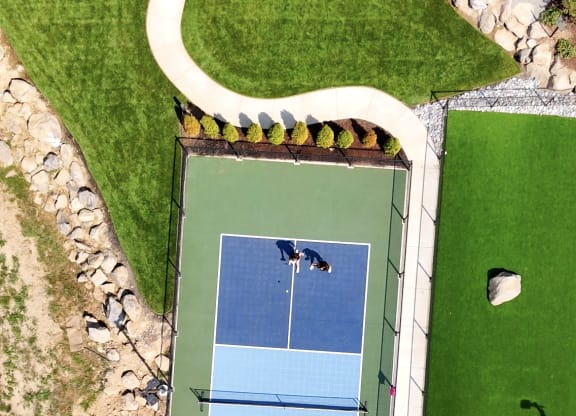 an aerial view of a tennis court on a green court