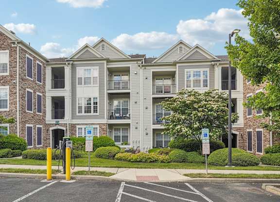 Apartment building with a parking lot in front.
