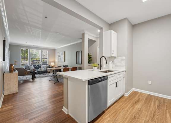A modern kitchen with a white island and wooden floors.