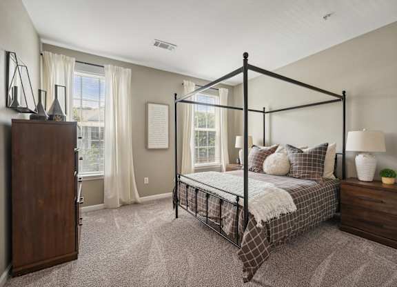 A bedroom with a four poster bed and a nightstand.