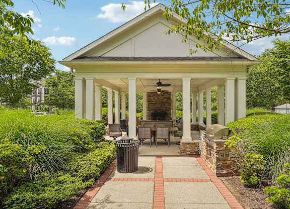 A white house with a porch and a brick walkway.