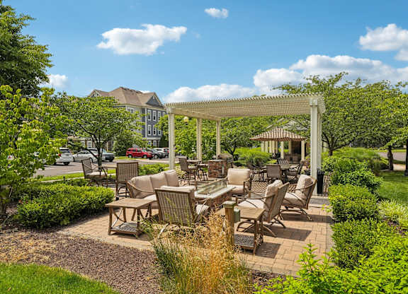 A patio with a table and chairs under a pergola.