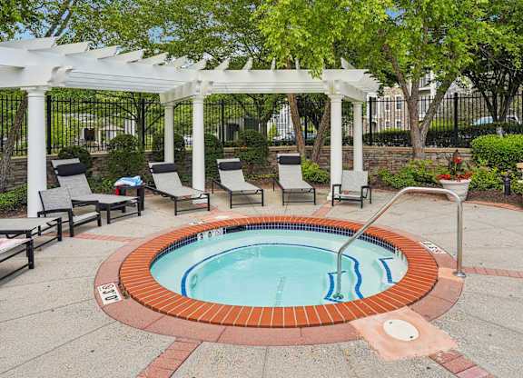A small pool with a white pergola above it.