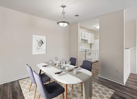 A dining room with a white table and chairs.