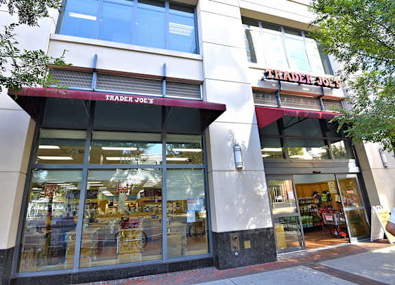 A storefront of Trader Joe's with a red awning and glass doors.