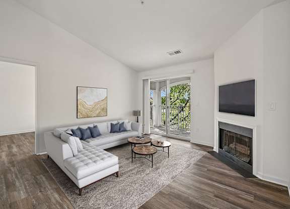 A living room with a white couch and a fireplace.
