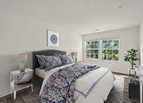 A bedroom with a large bed and a window overlooking trees.