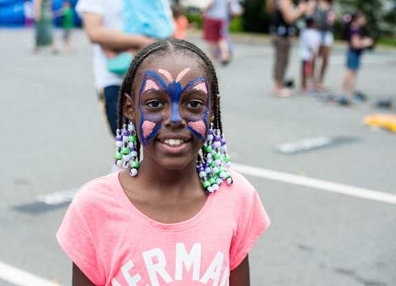 A girl with a butterfly painted on her face.