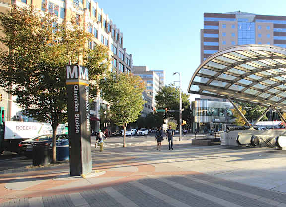 A city street with a pedestrian walkway and a bus stop.