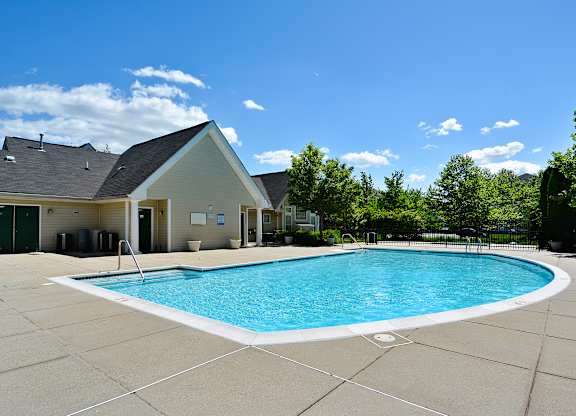 A small building is behind a pool.
