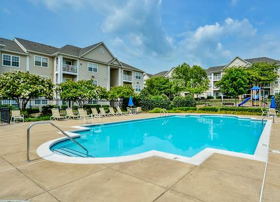 A large swimming pool in front of apartment buildings.