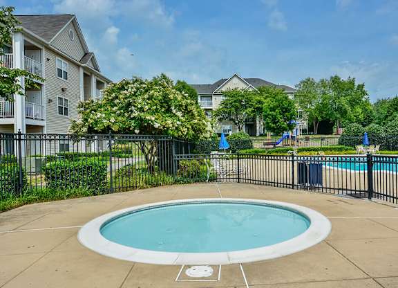 A small round pool surrounded by a black fence.