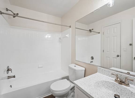 A white bathroom with a toilet, sink, and bathtub.