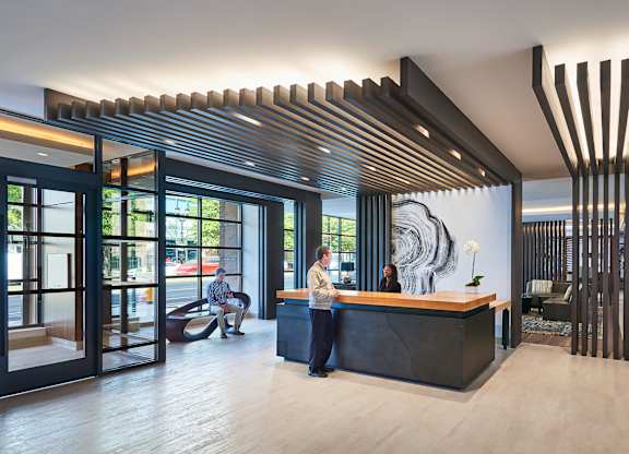 A reception area with a woman standing behind the desk.