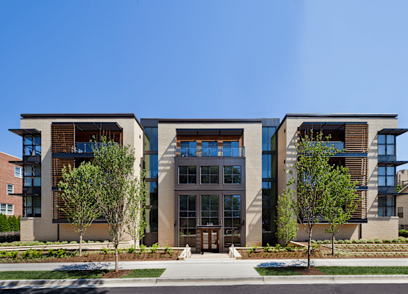 A modern building with a glass entrance and two trees in front.