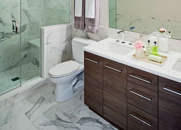 A bathroom with a marble floor and a white toilet.