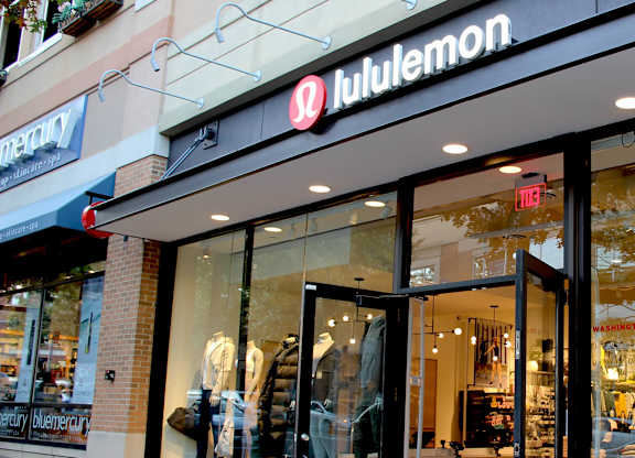 A woman is on a billboard outside of a lululemon store.