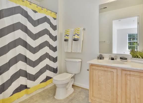 A bathroom with a toilet, a sink, and a shower curtain.