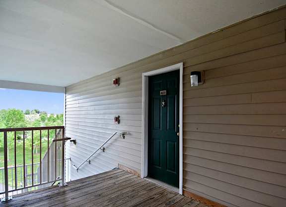 A green door is on the side of a house.