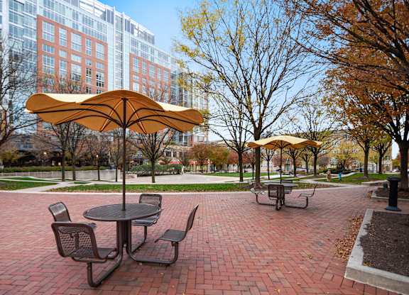 A yellow umbrella is over a round table with four chairs.