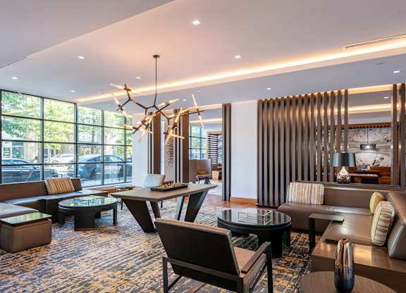 A modern living room with a large window and a chandelier.