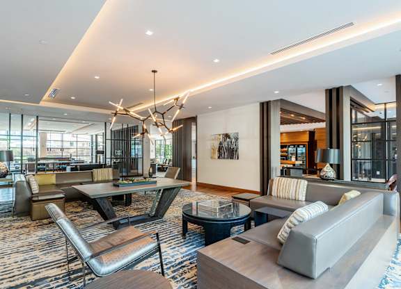 A modern living room with a large grey sofa and a wooden coffee table.