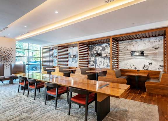 A modern dining room with a long table and chairs.