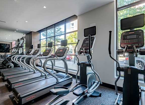 A gym with treadmills and elliptical machines.