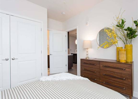 A bedroom with a bed, dresser, and mirror.
