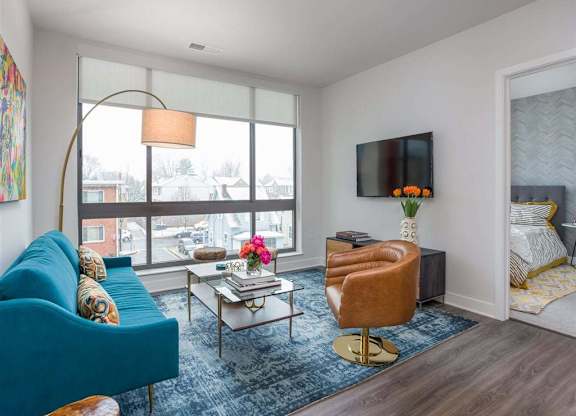 A living room with a blue couch, a coffee table, and a television.