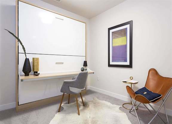 A room with a chair, a table, and a shelf with vases.