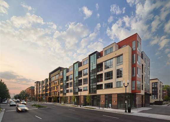 A modern apartment building with a mix of brick and glass facades.