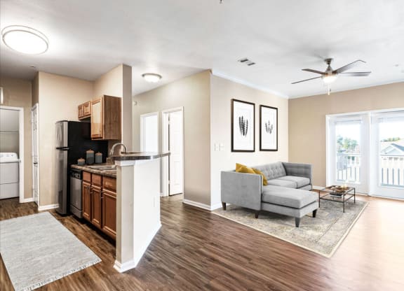 a living room with a couch and a coffee table next to a kitchen with a stove and at Tradition at Stonewater, Cary