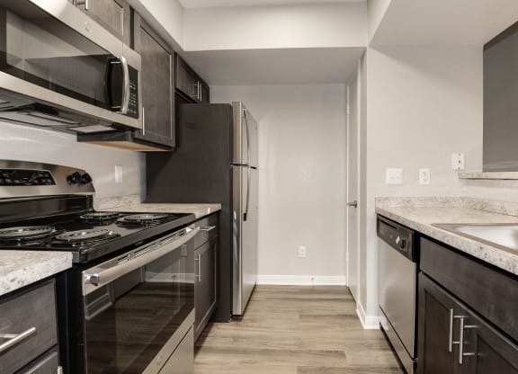 Kitchen with stainless steel appliances and dark cabinets at Elme Herndon, Herndon, VA