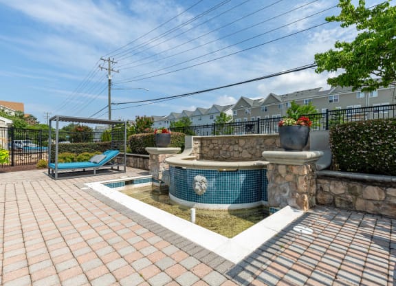 a backyard with a pool and a hot tub with a stone wall and a spa at Elme Dulles, Herndon, VA