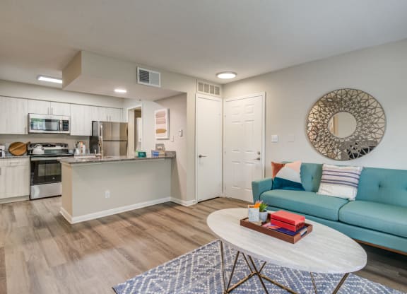 a living room and kitchen with a blue couch and a coffee table at Elme Herndon, Herndon, Virginia