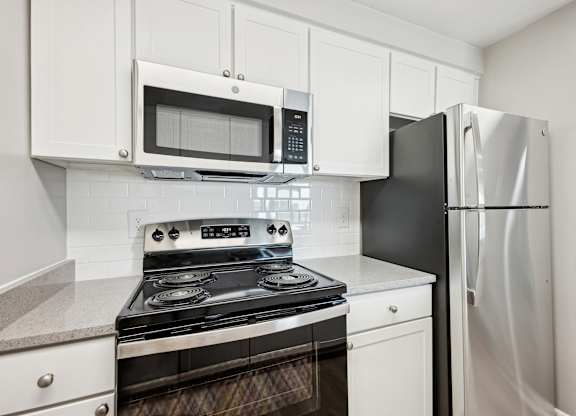 A kitchen with a black refrigerator and a black and silver stove  at Cascade at Landmark, Virginia